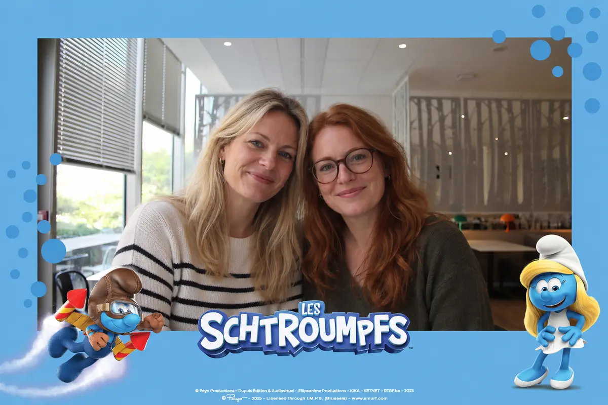 Tirage photobooth avec cadre officiel Les Schtroumpfs, deux invitées souriantes dans un bureau