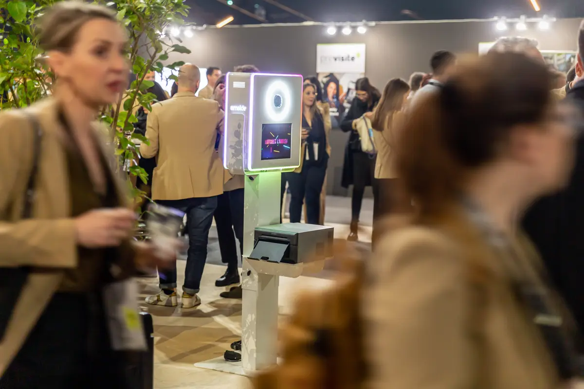 Borne photo Smakk allumée au milieu des visiteurs d'un salon professionnel