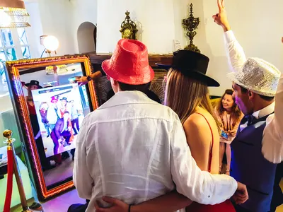 Invités du mariage posant avec des accessoires devant le photomaton